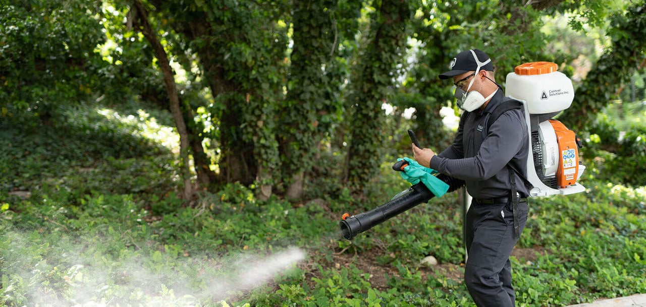 Hawx pest control technician spraying