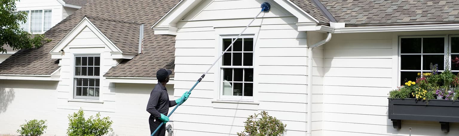 Hawx pest control technician treating a home exterior