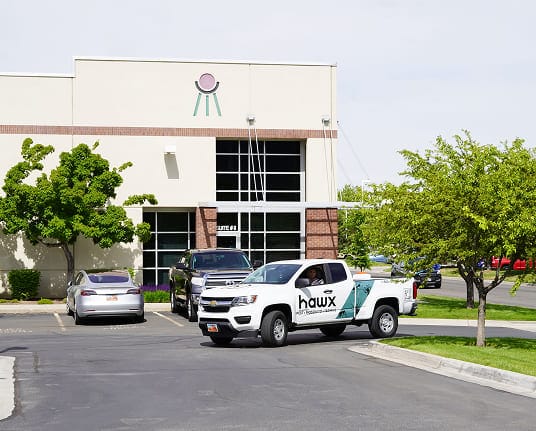 Hawx pest control vehicles outside a commercial building