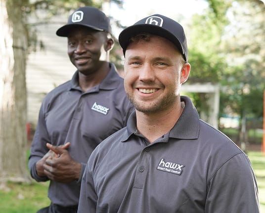 Two Hawx pest control technicians smiling outdoors