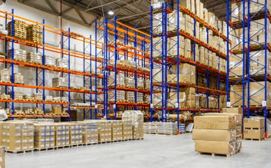 Large warehouse with tall shelving units stacked with boxes